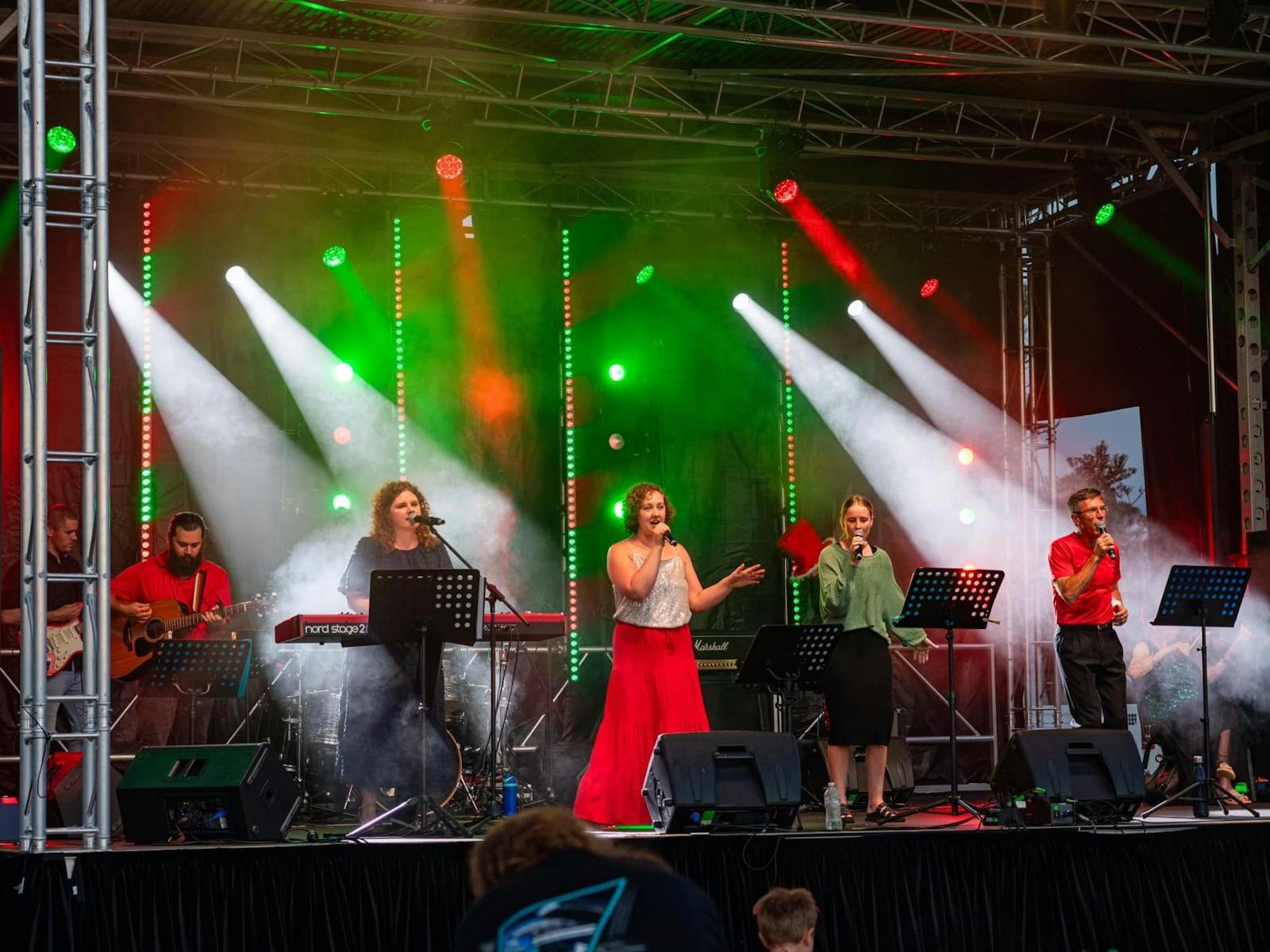 Riverside Carols singers on the illuminated Christmas stage